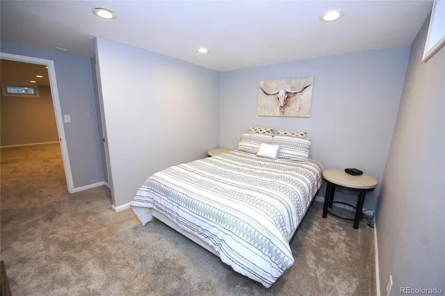 a bedroom with a bed and a painting on the wall