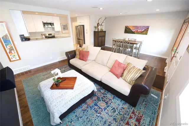 a living room with furniture and wooden floor