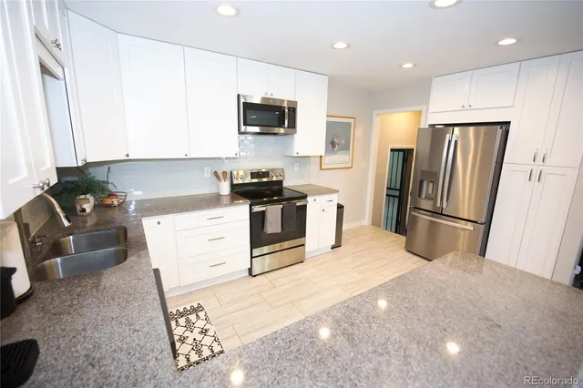 a kitchen with stainless steel appliances granite countertop a refrigerator stove microwave and sink