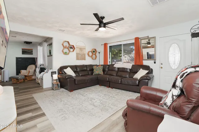 a living room with furniture a clock and a large window