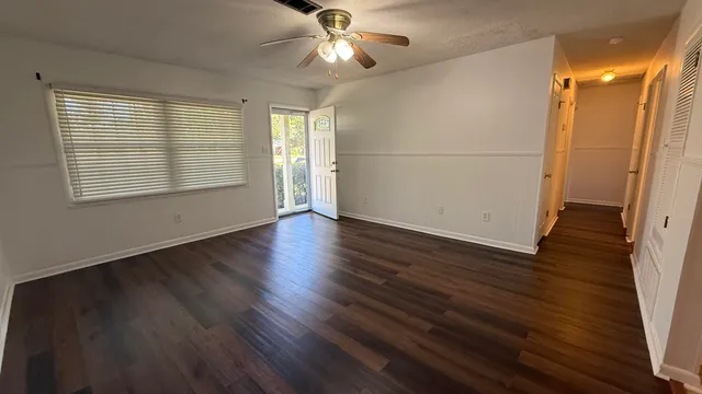 a view of a livingroom with wooden floor and a ceiling fan