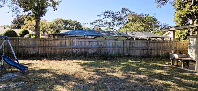 a backyard of a house with table and chairs