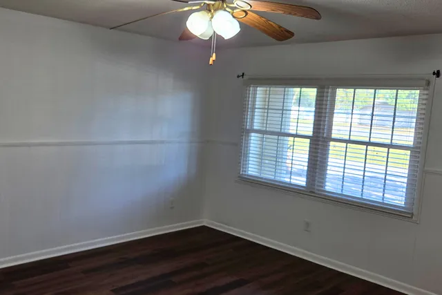 a view of a room with wooden floor and windows