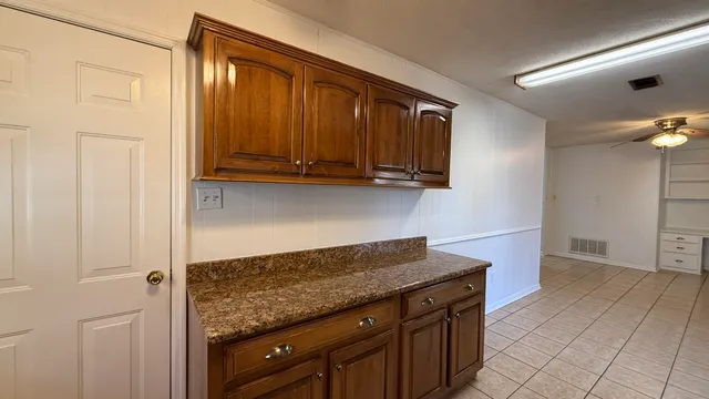 a kitchen with granite countertop a sink a stove and cabinets