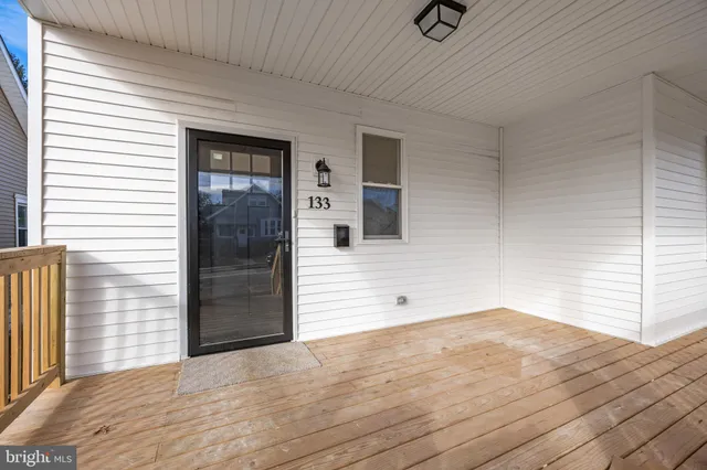 a view of a livingroom with wooden floor and a ceiling fan