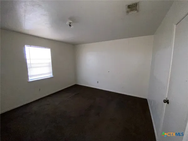 a view of an empty room and a window