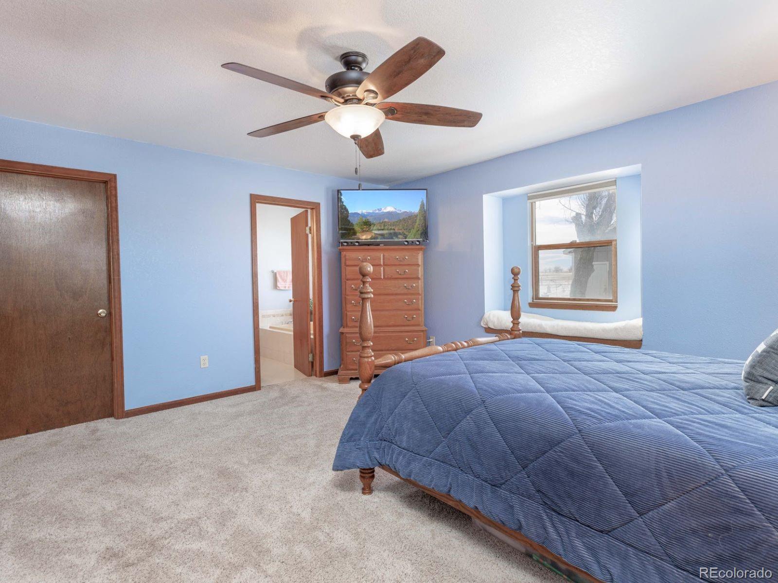 6115 Sengbeil Road Yoder, CO 80864 - Photo 14 of 43 a bedroom with a large bed chandelier and a window