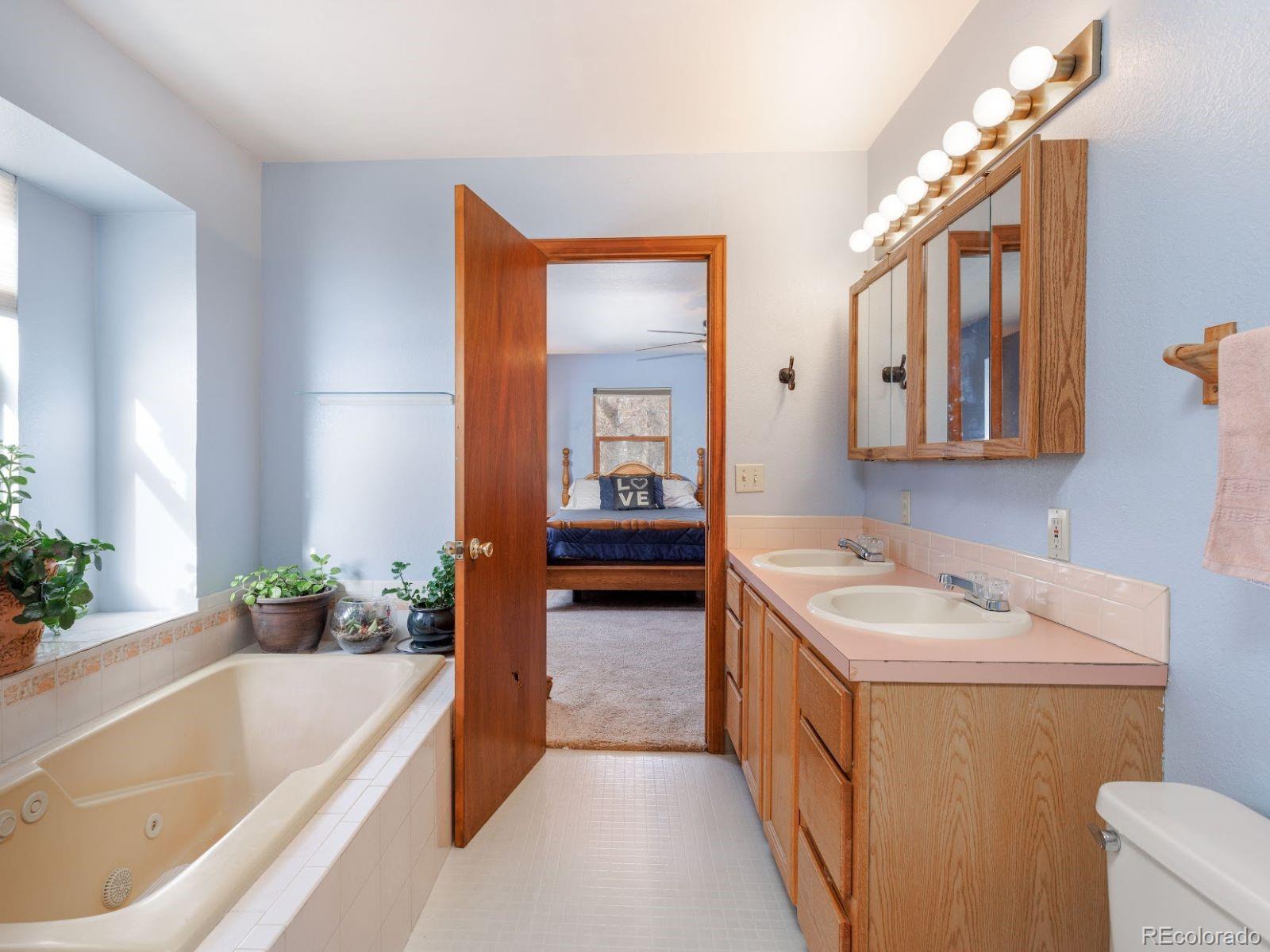 6115 Sengbeil Road Yoder, CO 80864 - Photo 15 of 43 a bathroom with a tub sink and mirror