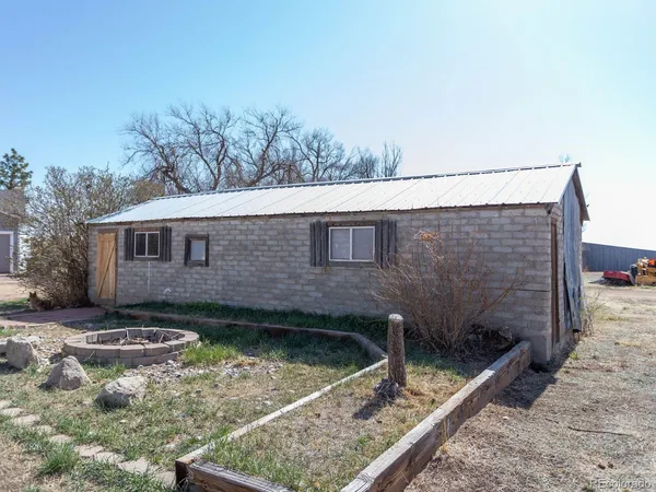 a view of a small house with backyard