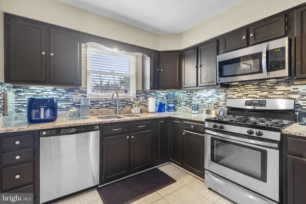 a kitchen with stainless steel appliances granite countertop a stove microwave and sink