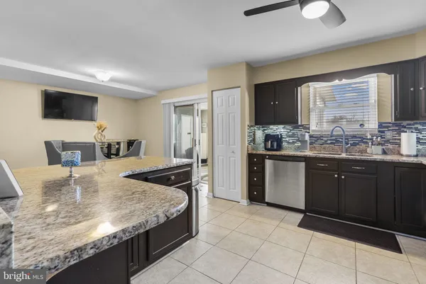a kitchen with kitchen island granite countertop a sink and refrigerator