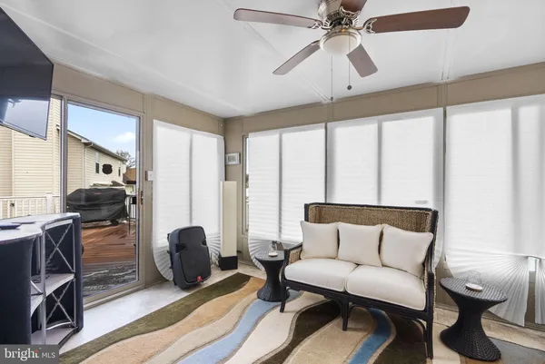 a living room with furniture a ceiling fan and a rug