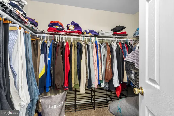 a view of walk in closet with clothes