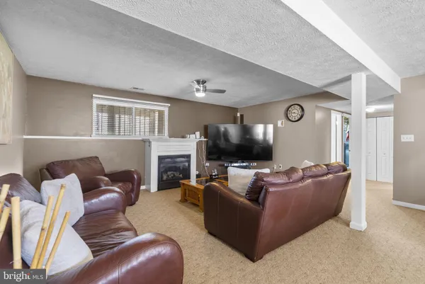 a living room with furniture a flat screen tv and a window
