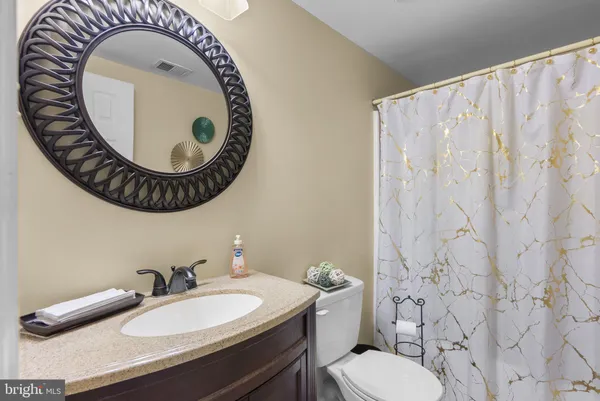 a bathroom with a sink a mirror a toilet and a mirror