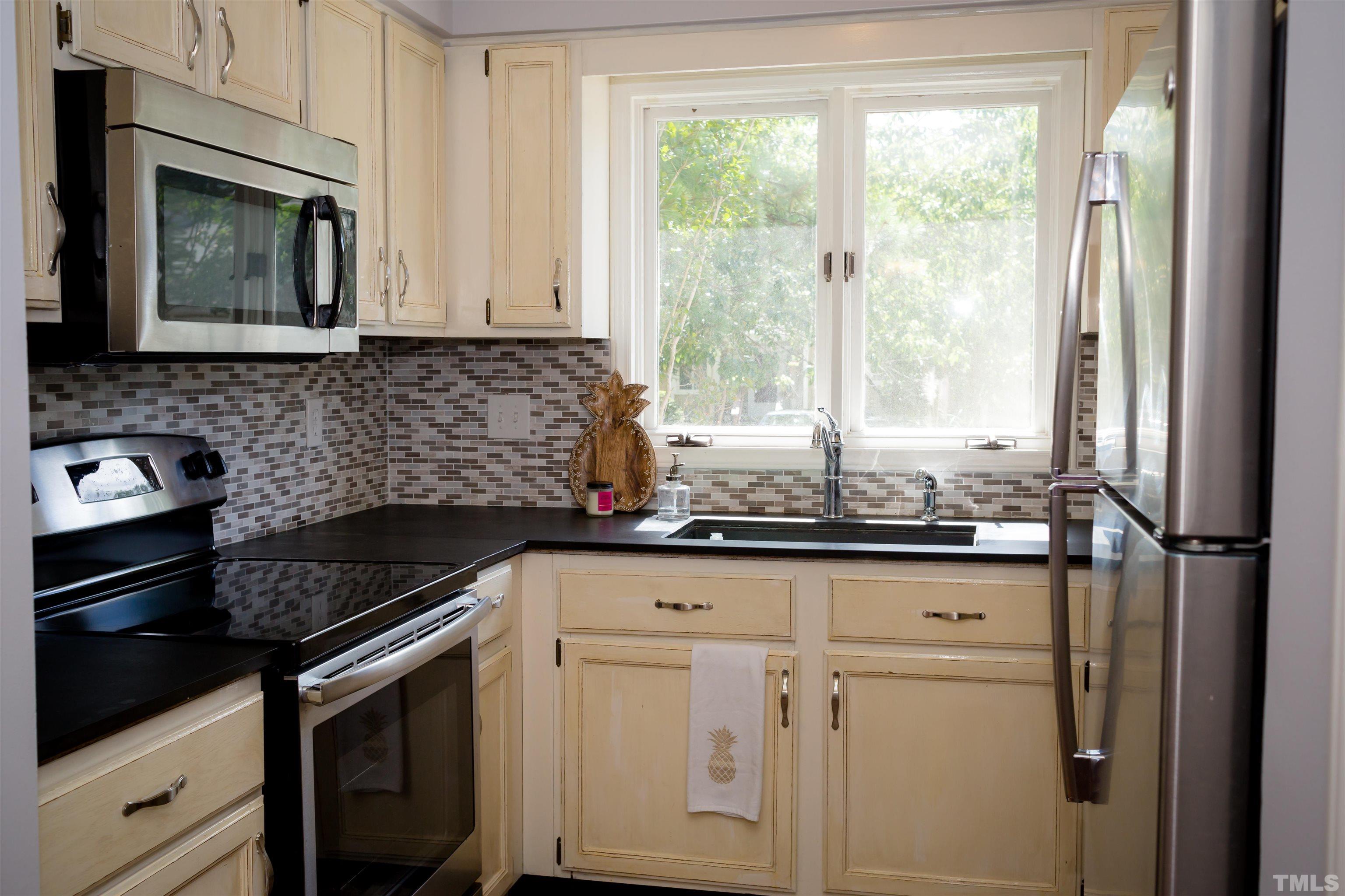 4326 Beechnut Lane Durham, NC 27707 - Photo 2 of 26 a kitchen with granite countertop white cabinets and white appliances