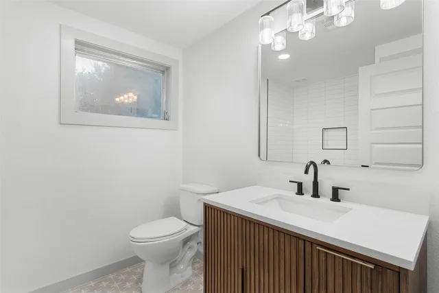 a bathroom with a sink vanity mirror and toilet