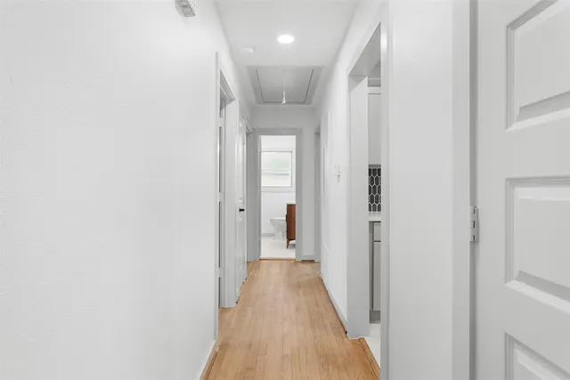 a view of a hallway with wooden floor and a large window