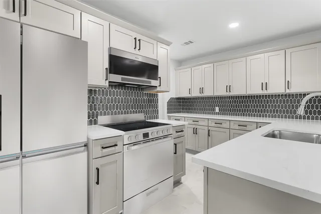 a kitchen with white cabinets and white appliances