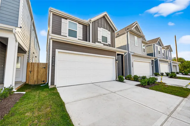 a front view of a house with a garden and garage