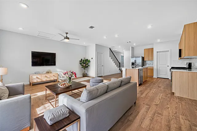 a living room with furniture and a wooden floor