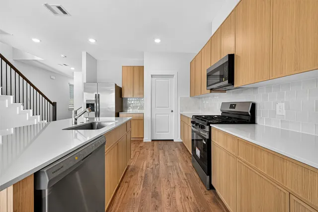 a kitchen with stainless steel appliances a stove a microwave cabinets and a counter top space