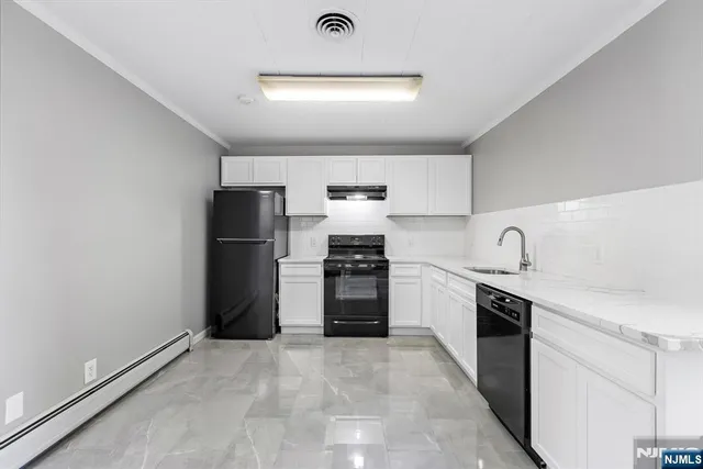 a kitchen with granite countertop a refrigerator and a sink