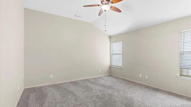 an empty room with a ceiling fan and bathroom