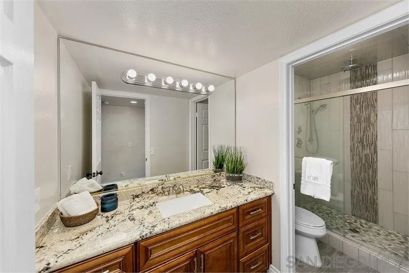 44113 Northgate Avenue Temecula, CA 92592 - Photo 19 of 30 a bathroom with a granite countertop sink a toilet and a mirror