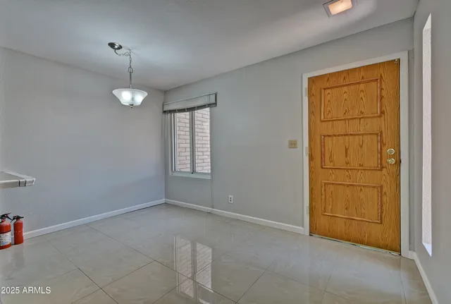 an empty room with chandelier fan