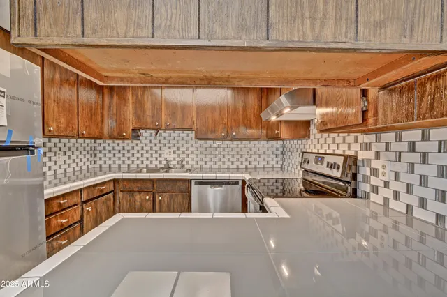 a kitchen with granite countertop a sink a stove and cabinets