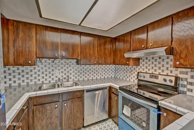 a kitchen with a stove a sink and cabinets