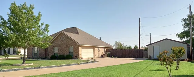 a front view of a house with a yard and potted plants