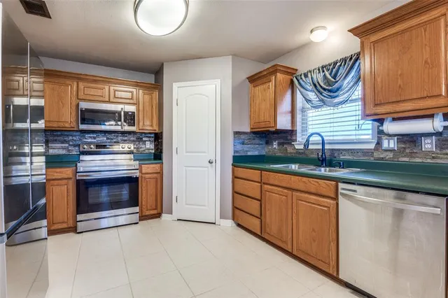 a kitchen with granite countertop a sink a stove and cabinets