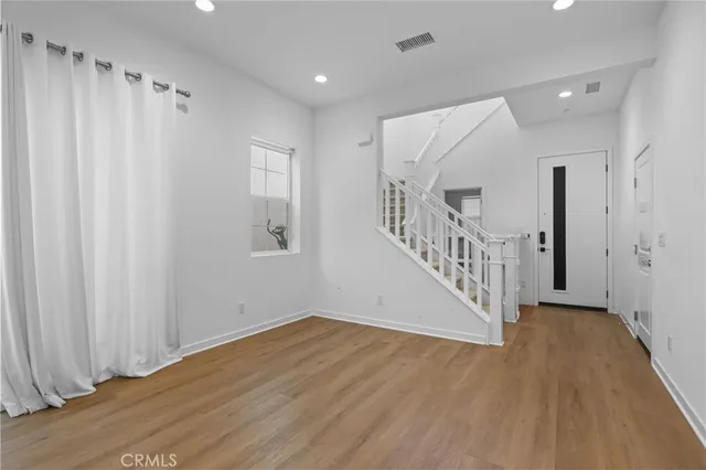 a view of a hallway with wooden floor and closet area