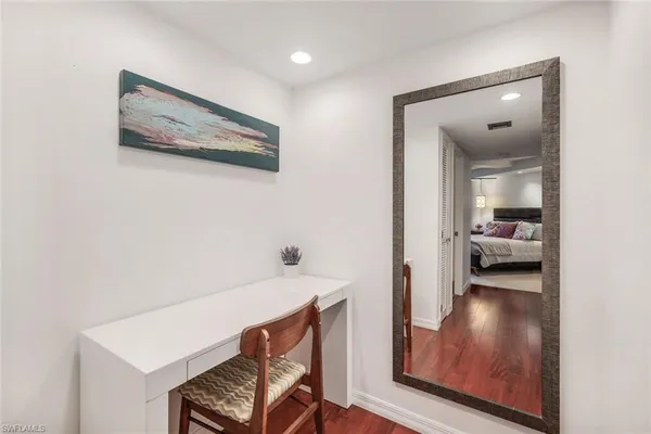 a view of a hallway and a livingroom with furniture
