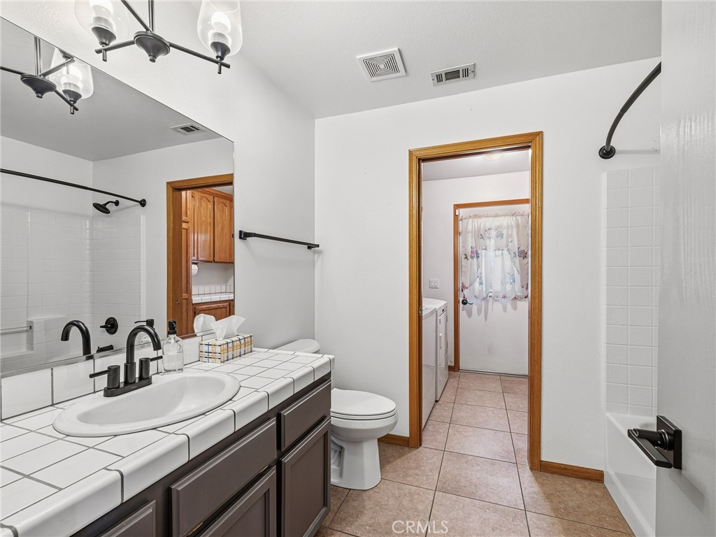 18965 Shetland Road Apple Valley, CA 92308 - Photo 19 of 45 a bathroom with a granite countertop sink a toilet and a mirror
