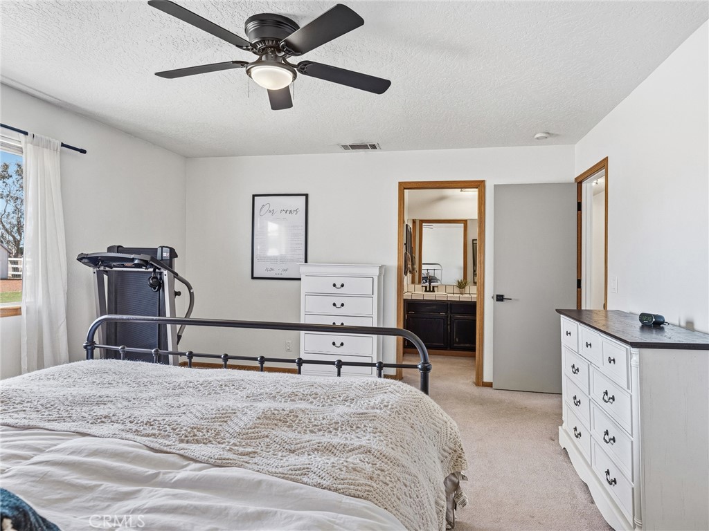 18965 Shetland Road Apple Valley, CA 92308 - Photo 26 of 45 a bedroom with a bed and a chandelier