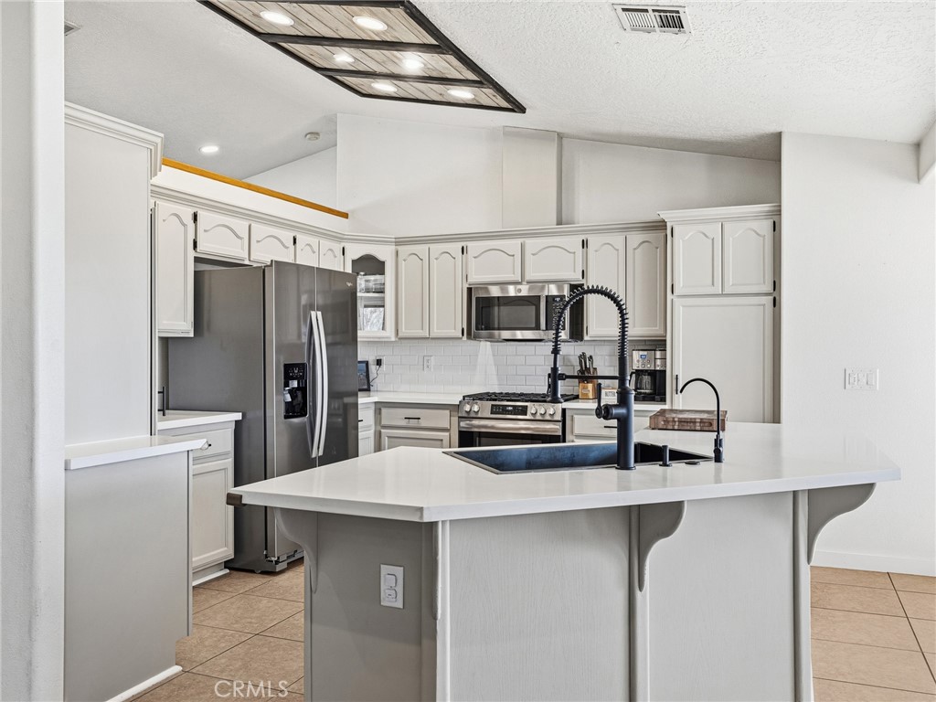 18965 Shetland Road Apple Valley, CA 92308 - Photo 8 of 45 a kitchen with stainless steel appliances a refrigerator and a stove top oven