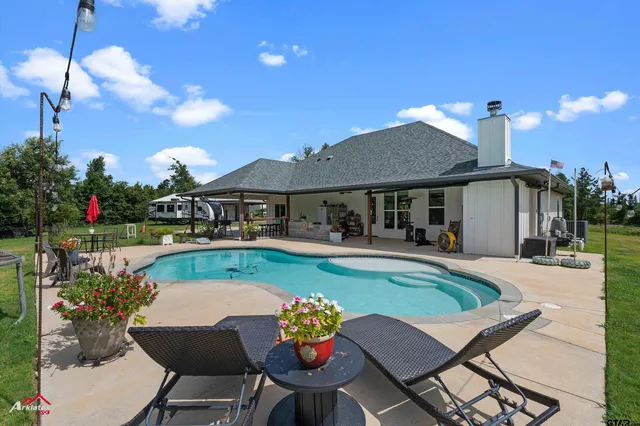 a swimming pool with outdoor seating and yard