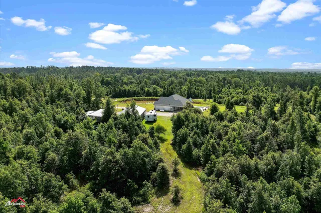an aerial view of a house with swimming pool and mountains