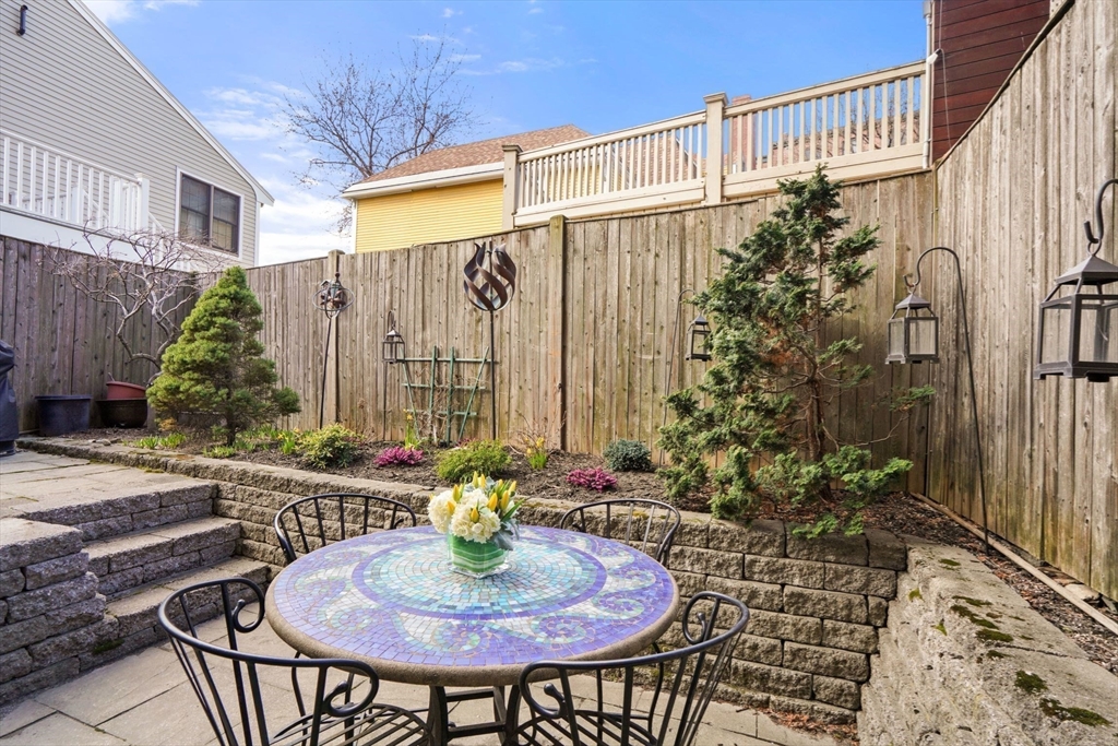 3 Harvard Place, Unit 1 Boston, MA 02129 - Photo 4 of 15 a backyard of a house with table and chairs