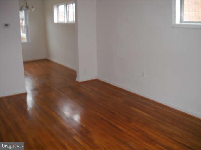 4412 Fenor Road Halethorpe, MD 21227 - Photo 2 of 8 a view of an empty room with wooden floor and a window
