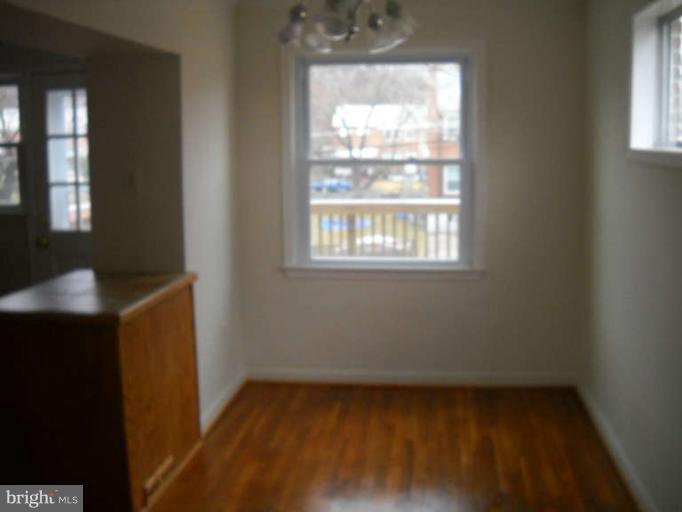 4412 Fenor Road Halethorpe, MD 21227 - Photo 3 of 8 a view of an empty room with wooden floor and a window