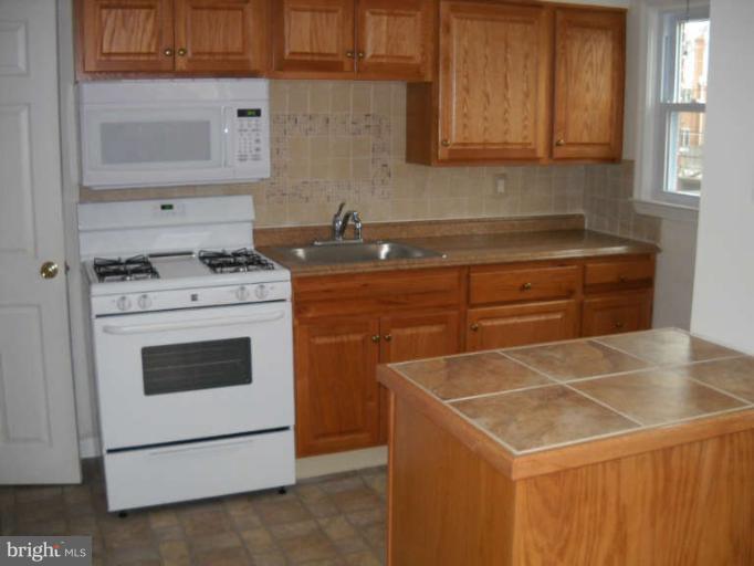 4412 Fenor Road Halethorpe, MD 21227 - Photo 4 of 8 a kitchen with a stove and a sink