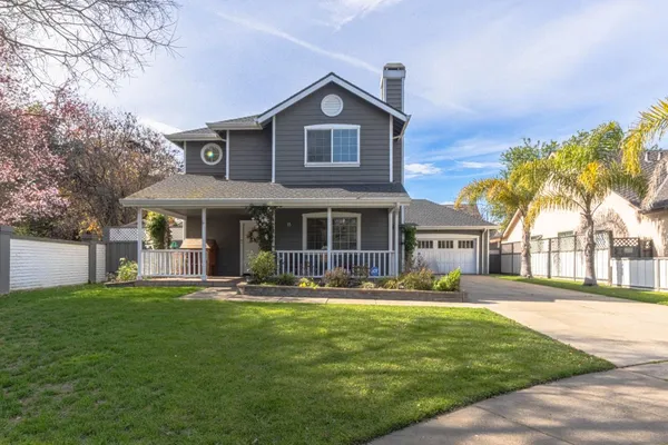 a front view of a house with a yard and trees