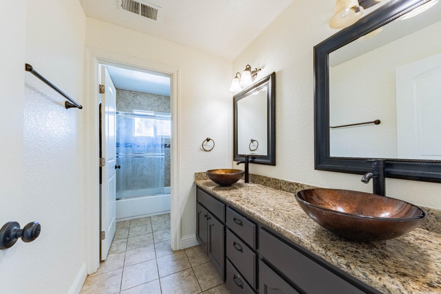 18 Hancock Circle Salinas, CA 93906 - Photo 23 of 36 a bathroom with a granite countertop sink a mirror and shower