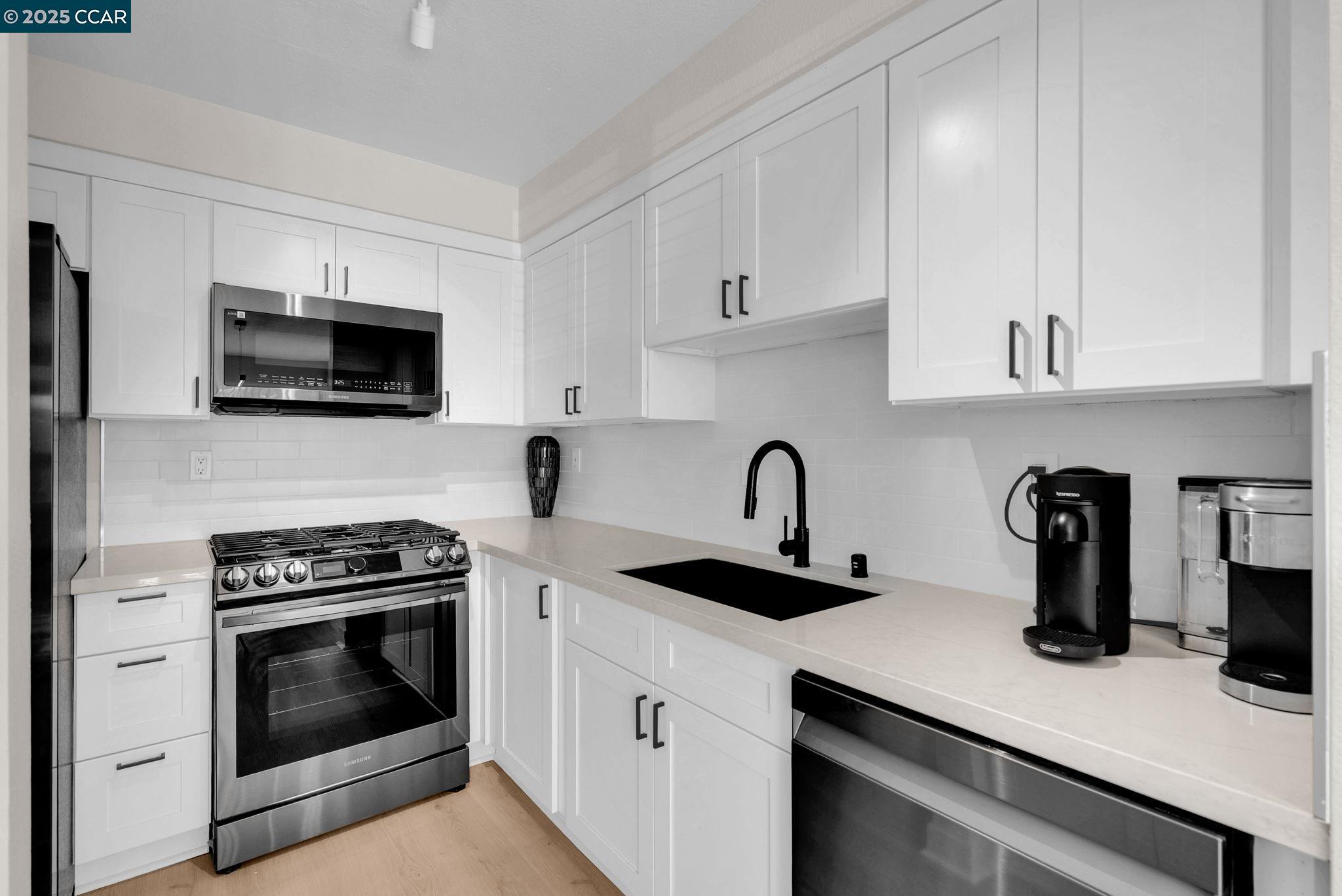 406 Olympus, Unit 5 Hercules, CA 94547 - Photo 11 of 49 a kitchen with cabinets stainless steel appliances and a counter space