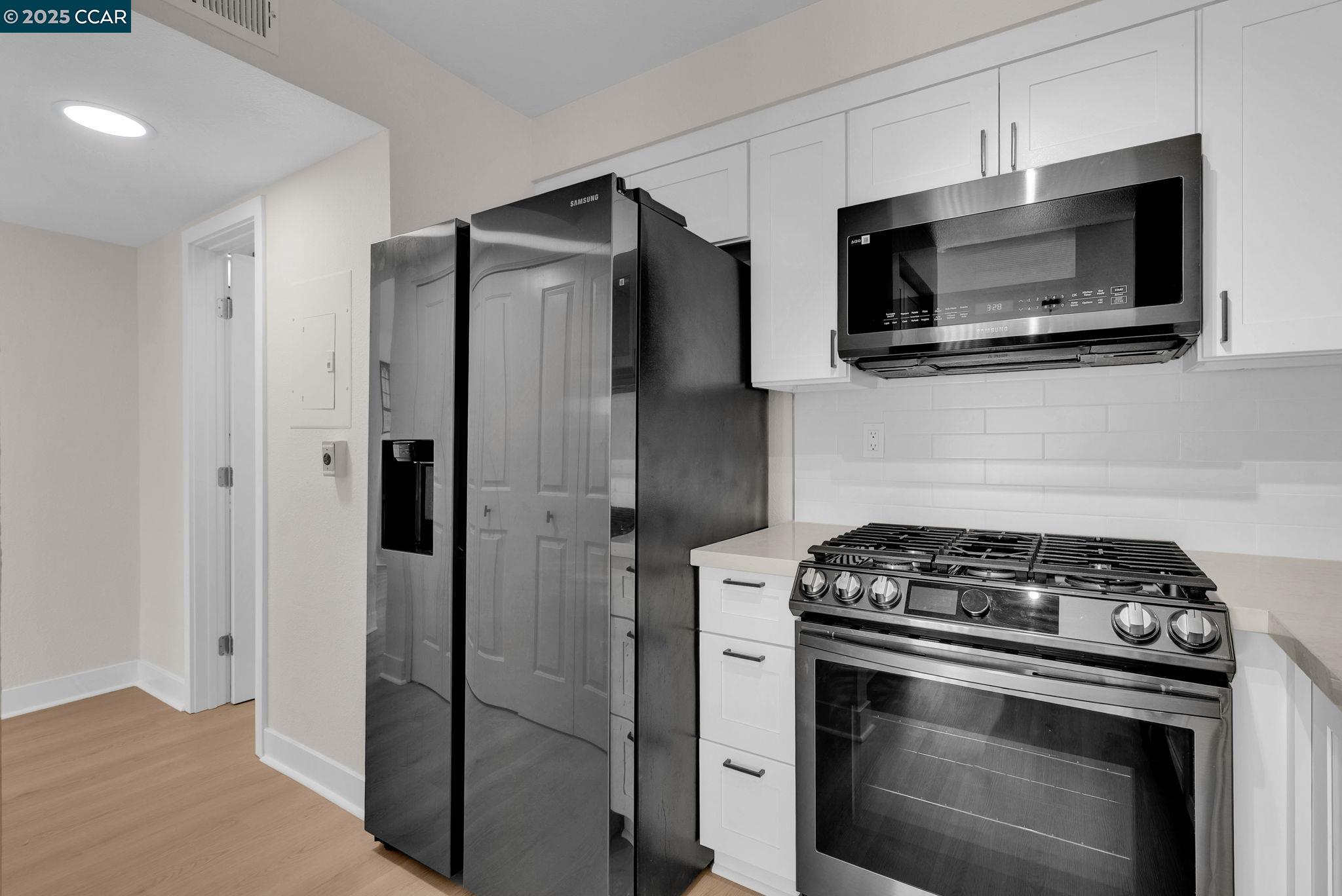 406 Olympus, Unit 5 Hercules, CA 94547 - Photo 14 of 49 a kitchen with stainless steel appliances white cabinets and a stove top oven