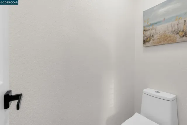 a white toilet sitting next to a white wall
